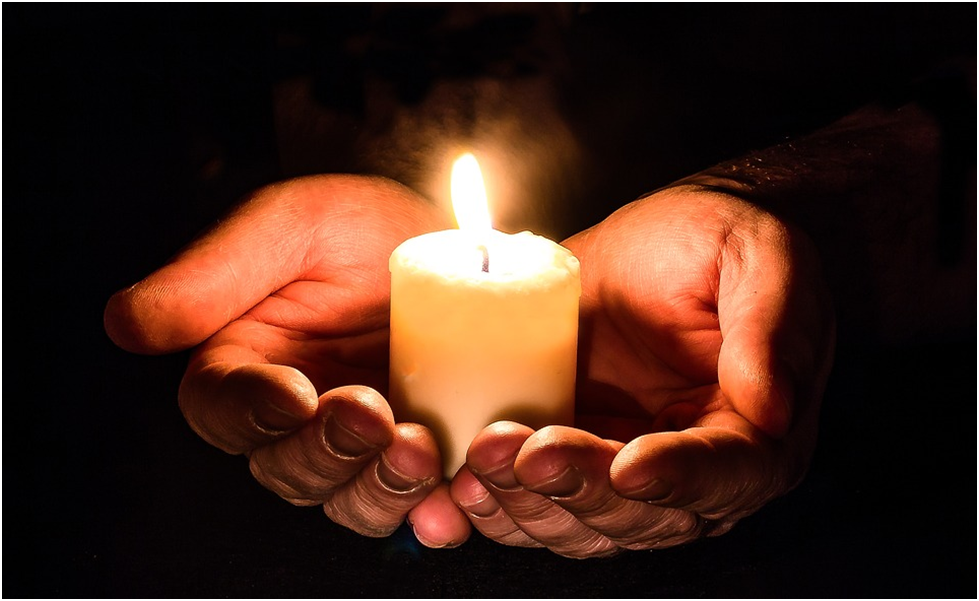 Hands holding a candle women sharing their frontline