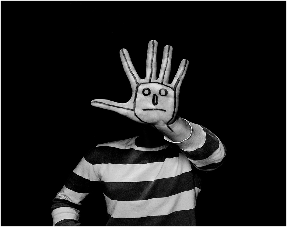 COMMUNICATION A MIME WITH SAD  FACE DRAWN ON HIS PALM